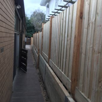 Timber paling fence with retaining wall